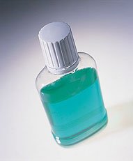 Turquoise mouthwash in clear bottle with white cap on white background.