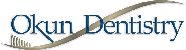 Okun Dentistry logo with blue text and curved design element