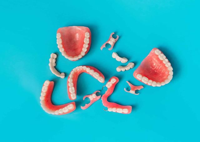 Grapefruit slices arranged to spell "Smile" on bright turquoise background for dental practice.