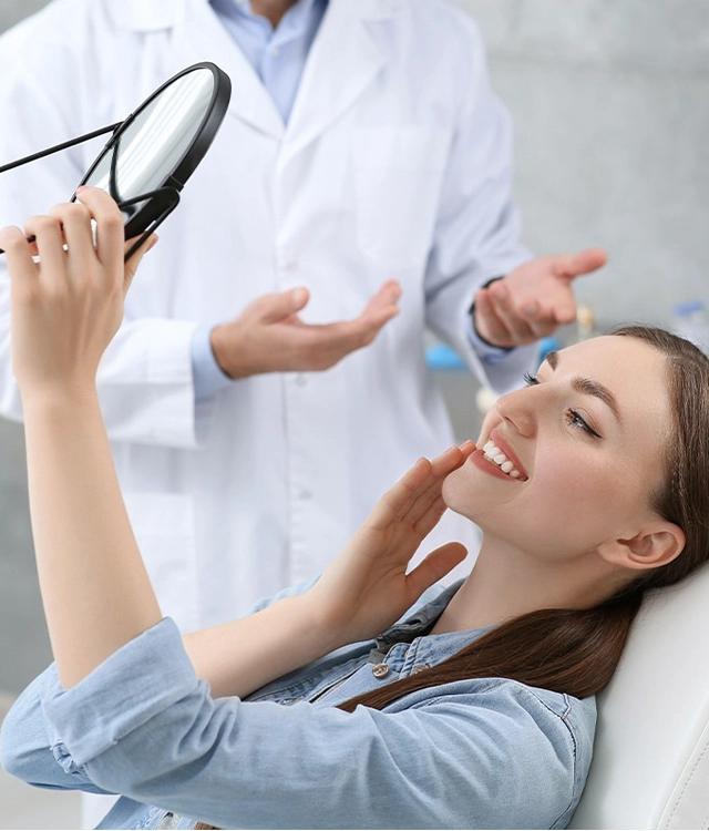 Dentist examining female patient's teeth during dental checkup in clinical setting.