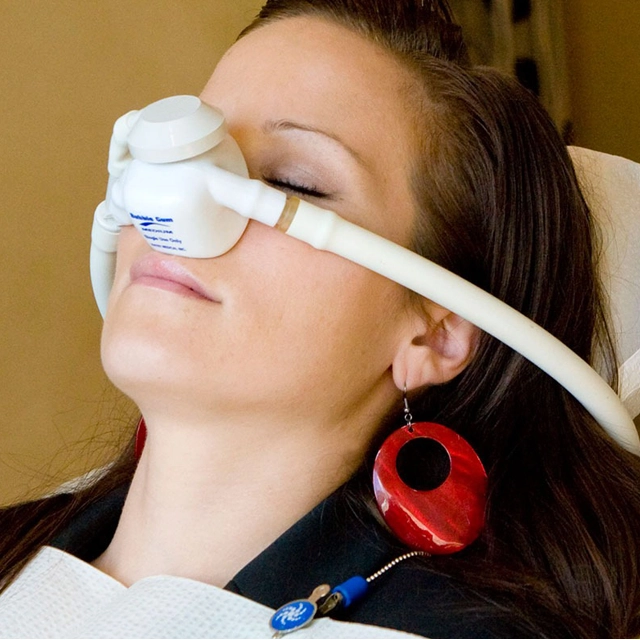 Woman wearing protective eyewear during dental procedure at Okun Dentistry office.